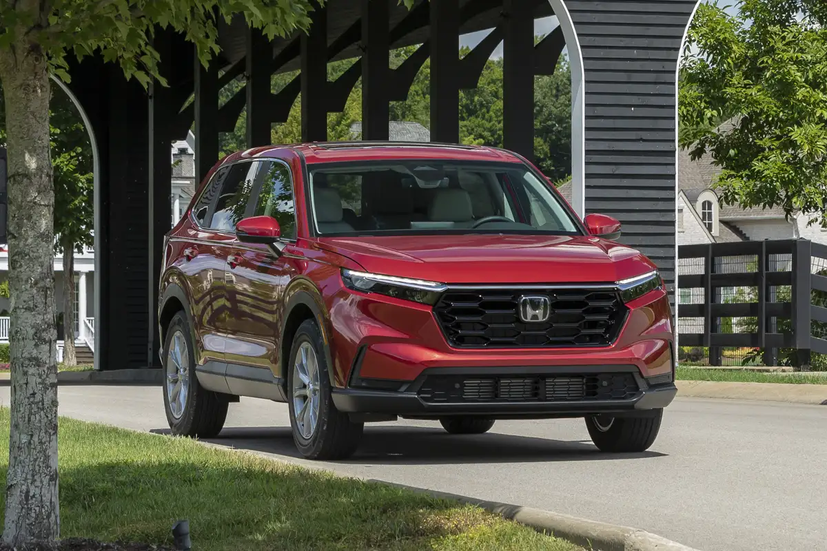 Xe ô tô Crossover Honda CR-V màu đỏ đỗ trước kiến trúc tòa nhà hiện đại.