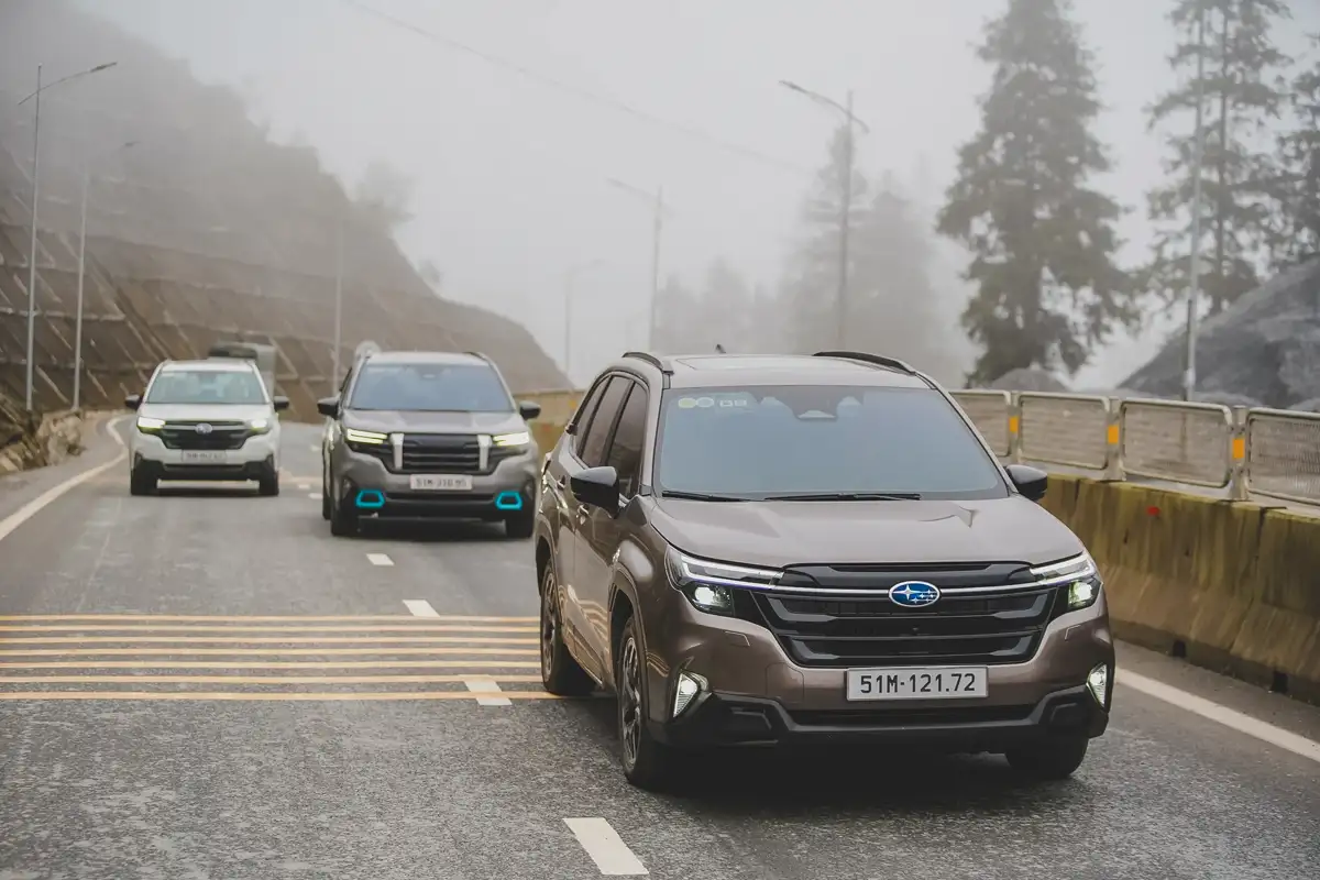 Xe SUV Subaru Forester thế hệ mới dẫn đầu đoàn xe chạy trên đường đèo dốc quanh co trong thời tiết sương mù dày đặc.