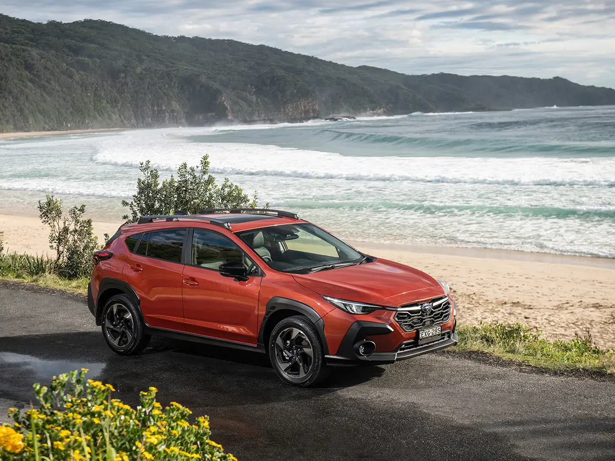 Subaru Crosstrek màu cam trên cung đường ven biển, phù hợp cho khách hàng thường xuyên đi đường đèo, mưa trơn và cần một mẫu SUV an toàn, linh hoạt.